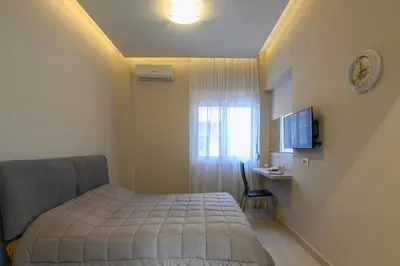 a small bedroom with a bed and a window at Just For Two in Chania Town