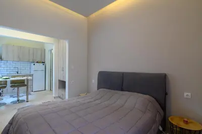 a bedroom with a large bed and a kitchen at Just For Two in Chania Town