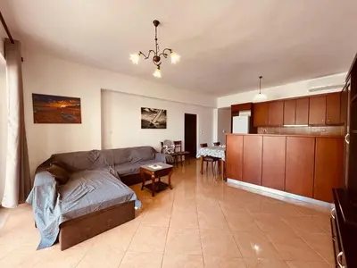 a living room with a couch and a kitchen at Alcyone Apartment in Kissamos