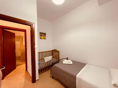 a bedroom with a bed and a baby crib at Alcyone Apartment in Kissamos