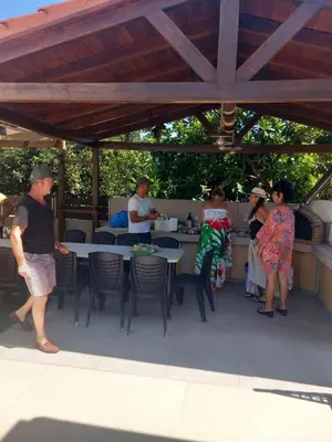 a group of people sitting at tables in a patio at Giannis Villa in Skinés