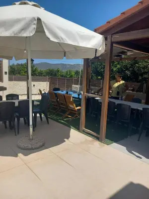 a person sitting at a table under an umbrella at Giannis Villa in Skinés