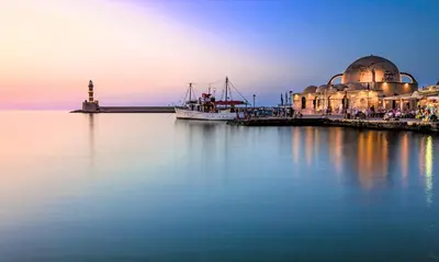 a boat is docked next to a building on the water at Orientem Villa Heated Pool in Georgioupoli