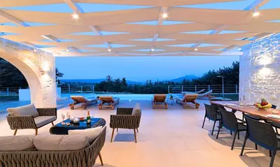 a patio with chairs and a table and a pool at Orientem Villa Heated Pool in Georgioupoli