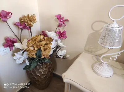 a vase filled with flowers sitting next to a table at BLUE EYES VILLA in Chania Town