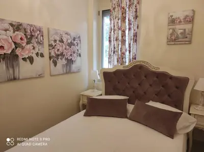a bedroom with a bed and a window with flowers at BLUE EYES VILLA in Chania Town