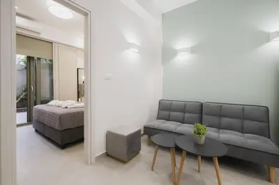 a living room with a couch and a bed and a table at Peris 5 with Yard steps to Bus St & Old Town in Chania Town