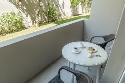 a small table with a teddy bear sitting on a balcony at Rhoe Seaside Apartments in Agia Marina Nea Kydonias