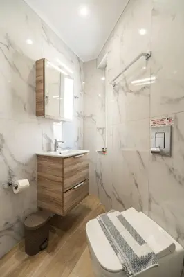 a bathroom with a toilet and a sink at Rhoe Seaside Apartments in Agia Marina Nea Kydonias
