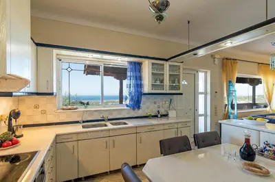 a large kitchen with a view of the ocean at Sea Breeze & Stunning Views - Pool Dream Gem in Dhémbla