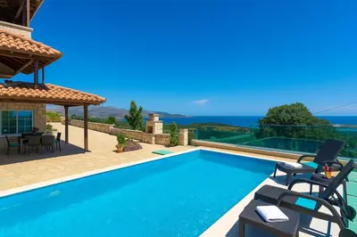 a villa with a swimming pool and a house at Sea Breeze & Stunning Views - Pool Dream Gem in Dhémbla