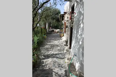 a narrow alley with a building and a wall at Olga's traditional stone house, Palaiochora in Kondokiníyion