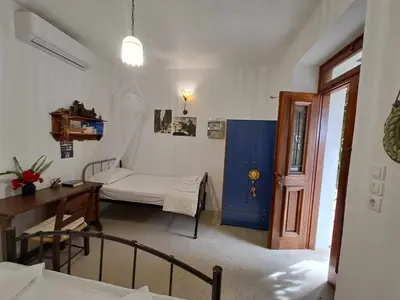 a hospital room with a bed and a table and a door at Olga's traditional stone house, Palaiochora in Kondokiníyion