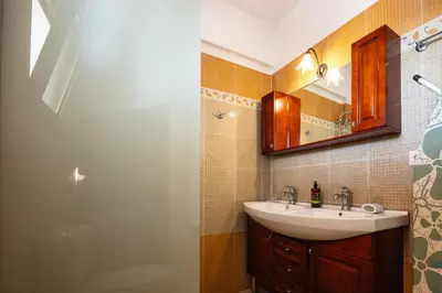 a bathroom with a sink and a mirror at Villa Aliki ,Aegean Sea Breeze 750m from the Beach! in Chania Town
