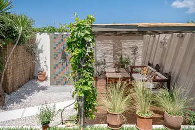 a patio with a table and a bunch of plants at The House By The Sea in Kato Daratso