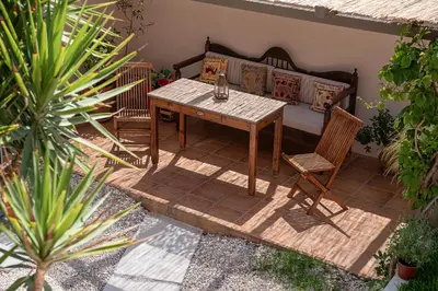 a patio with a wooden table and two chairs at The House By The Sea in Kato Daratso