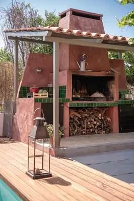 a outdoor pizza oven on a deck next to a pool at The House By The Sea in Kato Daratso