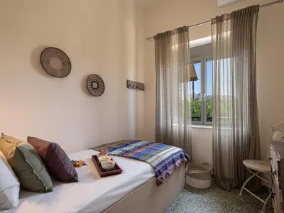 a small bedroom with a bed and a window at The House By The Sea in Kato Daratso