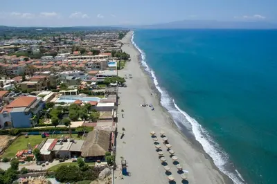 an aerial view of a beach with umbrellas and the ocean at 