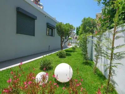 a garden with two white balls in the grass at Villa Belle Helene Kalamaki Chania in Kalamaki Chanion