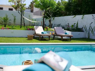 two chairs sitting next to a swimming pool at Villa Belle Helene Kalamaki Chania in Kalamaki Chanion