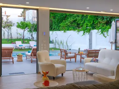 a living room with a patio with chairs and tables at Villa Belle Helene Kalamaki Chania in Kalamaki Chanion