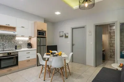 a kitchen with a table and chairs in a room at JT Apartments in Kissamos