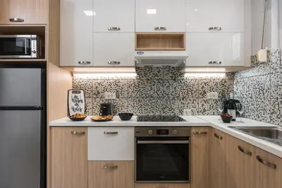 a kitchen with white cabinets and a stove top oven at JT Apartments in Kissamos