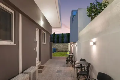 a hallway of a house with chairs and a table at JT Apartments in Kissamos