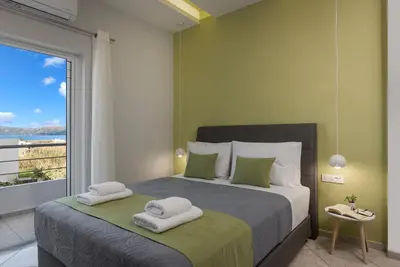a bedroom with a large bed with towels on it at JT Apartments in Kissamos