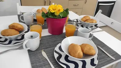 a table with plates of food and glasses of orange juice at Nikis Apartment 3 in Chania Town