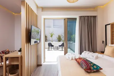 a bedroom with a bed and a balcony with a table at Villa Aroma in Chania Town
