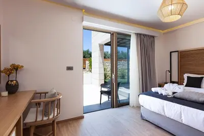 a bedroom with a bed and a desk and a balcony at Villa Aroma in Chania Town