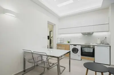 a white kitchen with a table and chairs in it at Peris 3 - Central Apt near Old Town - AC, Wifi in Chania Town