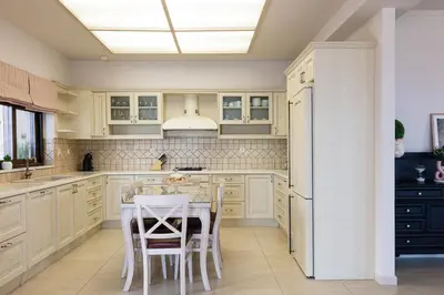 a kitchen with white cabinets and a table with chairs at Villa Golden Hill in Chania Town
