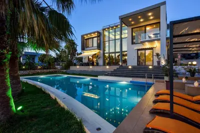 a large house with a swimming pool in front of it at Adorno Luxury Villa in Chorafakia