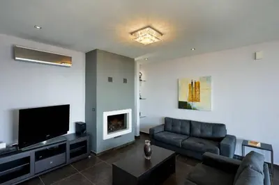 a living room with a couch and a flat screen tv at Adorno Luxury Villa in Chorafakia