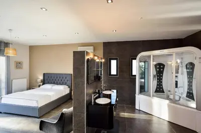 a bedroom with a bed and a sink and a mirror at Adorno Luxury Villa in Chorafakia