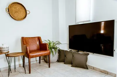 a living room with a tv and a chair and a table at Chania Paradise Retreat - Falasarna Villa Nostalgia in Plátanos