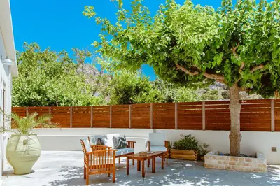 a patio with a table and chairs and a tree at Chania Paradise Retreat - Falasarna Villa Nostalgia in Plátanos