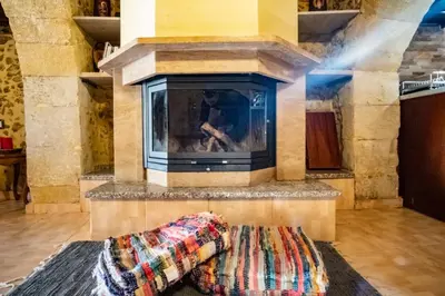 a living room with a fireplace and a rug at Villa Styliani in Kissamos
