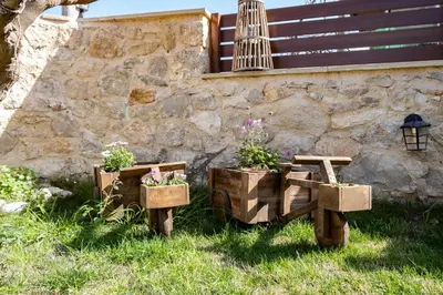 a garden with two flower boxes and a stone wall at Villa Styliani in Kissamos