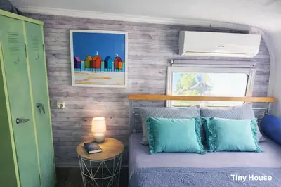 a tiny house bedroom with a bed and a window at dream tiny house & luxury tent, 6 km from center Chania in Chania Town