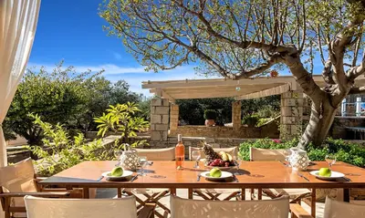 a wooden table and chairs in a garden at Cretan Kera Villa Heated Pool in Kerá