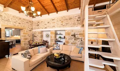 a living room with a couch and a spiral staircase at Cretan Kera Villa Heated Pool in Kerá
