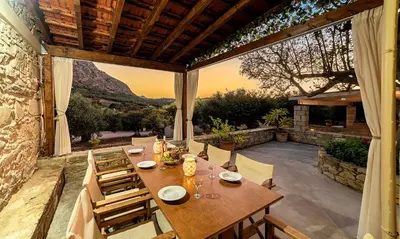 a wooden table and chairs on a patio at Cretan Kera Villa Heated Pool in Kerá