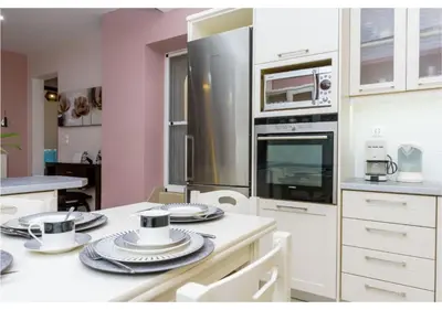 a kitchen with white cabinets and a stove top oven at Andronikis House in Pithárion