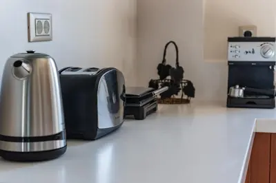 a kitchen with a counter top with a toaster and a microwave at Villa Pervoli in Varípetron