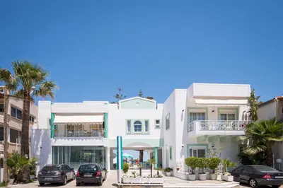 a white building with cars parked in front of it at Kristall Suites in Stalos