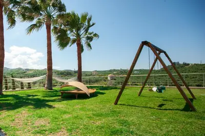 a swing set in a yard with palm trees at Luxury 6-Bedroom Villa With Private Pool- Villa Prigipessa in Chania Town